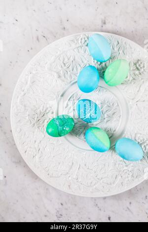 Dyed Easter eggs with batik patterns on a ceramic plate Stock Photo