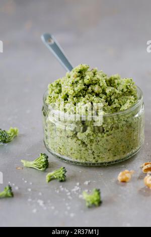 Broccoli and walnut pesto in a glass ramekin with a ceramic spoon Stock Photo