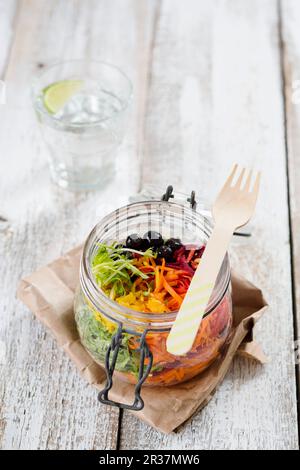 Rainbow salad in an open glass jar with beetroot, carrots, yellow pepper, lettuce and blueberries Stock Photo