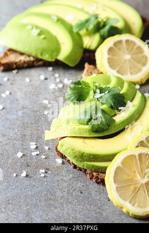 Avocado sandwich on dark rye bread made with fresh sliced avocados from above Stock Photo