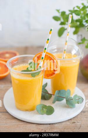 Sweet Smoothie In Plastic Cups On Wooden Table Stock Photo, Picture and  Royalty Free Image. Image 127579885.