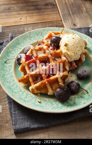 Round Belgian waffles with cherries, cherry sauce and vanilla ice cream Stock Photo