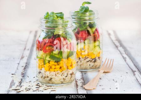 Rice salad in a glass jar with wild rice, sweetcorn, cucumber, tomato and lamb's lettuce Stock Photo