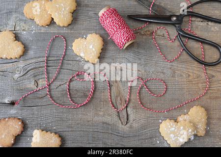 Heart shaped cookies and striped string spelling out the word 'love' Stock Photo