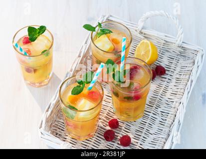 Fruity iced tea with mint on a white basket tray Stock Photo