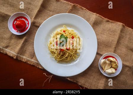 aglio e olio. Italian Pasta Spaghetti, aglio olio e pepperoni ,spaghetti with garlics, olive oil and chilli peppers on plate on table Stock Photo