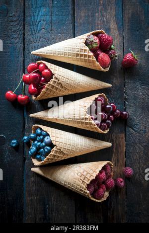 Various berries and cherries in ice cream cones Stock Photo