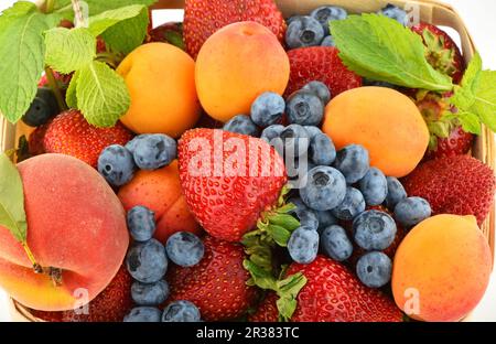 Strawberries, apricots, blueberries, peach and mint isolated on white Stock Photo