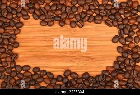 Coffee beans border frame over bamboo wood background Stock Photo