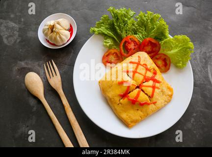 nasi goreng pattaya or Pattaya Fried Rice (Stuffed Omelette Fried Rice). Southeast Asian dish made by covering or wrapping chicken fried rice, in thin Stock Photo