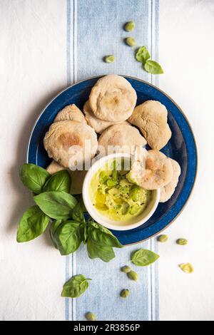 Mini pita breads with bean cream and basil Stock Photo