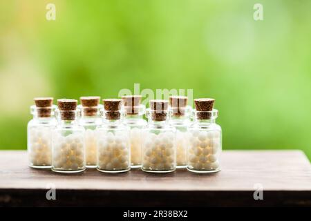 Scattered homeopathic globules and bottle on wooden background. Homeopathy  medicine Stock Photo - Alamy