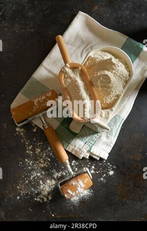 Flour in an old ceramic drawer with a wooden scoop and a rolling pin Stock Photo