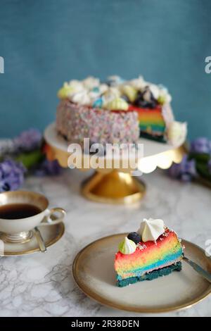 A slice of rainbow cheesecake on a plate Stock Photo
