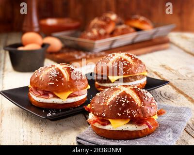 Lye bread rolls with bacon, cheese and fried egg Stock Photo