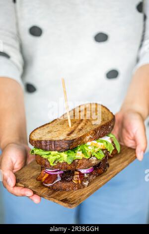 A grilled sandwich with vegetables, egg and bacon Stock Photo