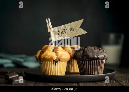 Vanilla and chocolate muffins with chocolate chunks and paper flags Stock Photo