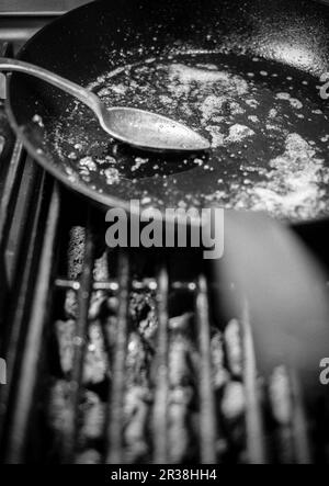A spoon in a used pan on a grill Stock Photo