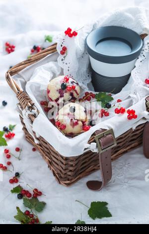 Vegan redcurrant muffins and coffee to go in a basket Stock Photo