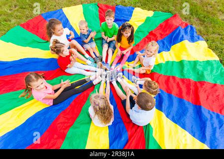 Kids holding hands together with teacher in gym Stock Photo