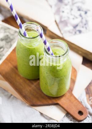 Green vegan smoothie in two small bottles Stock Photo