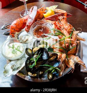 Fresh seafood platter with red lobster, langoustine, prawns, mussels, oysters, clams, with a tartare and sweet chilli sauce Stock Photo