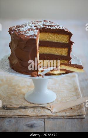 A three-layer chocolate cream cake, sliced Stock Photo