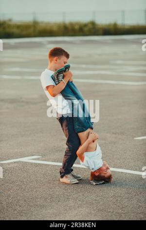 The boy standing upside down in the summer outdoors Stock Photo