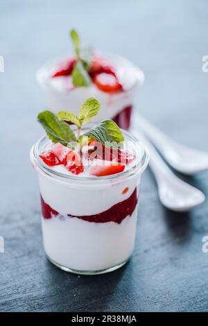 Yoghurt dessert with strawberry jam, fresh strawberries and mint Stock Photo