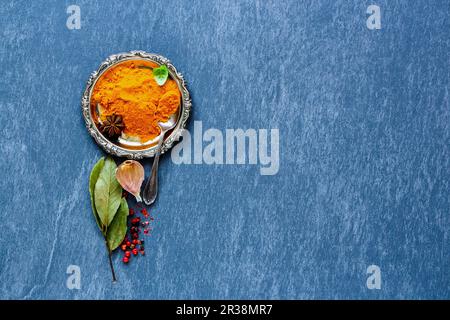 Turmeric powder with herbs and spices selection for cooking on grey stone background Stock Photo