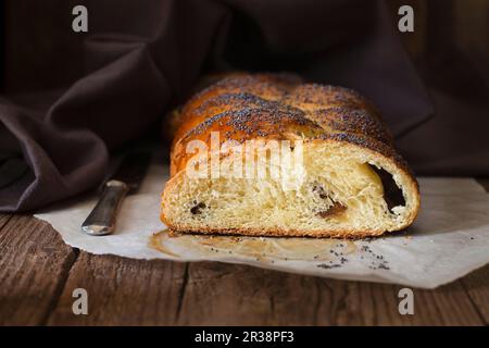 Sweet bread with poppyseeds, sliced on a piece of baking paper Stock Photo