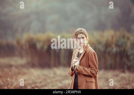 Lonely girl on a walk in the autumn field Stock Photo