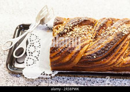 A sliced nut plait served on a doily on a tray Stock Photo
