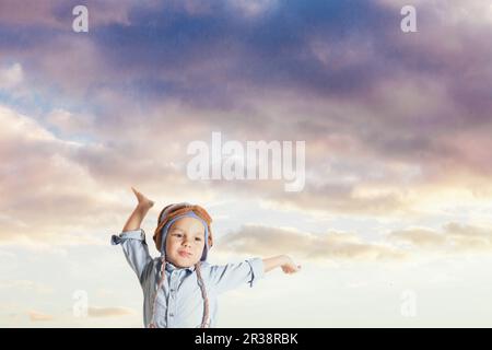 Cute boy pretending to be a pilot holding his hands up Stock Photo