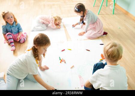 Top view of cute kids drawing on a floor Stock Photo