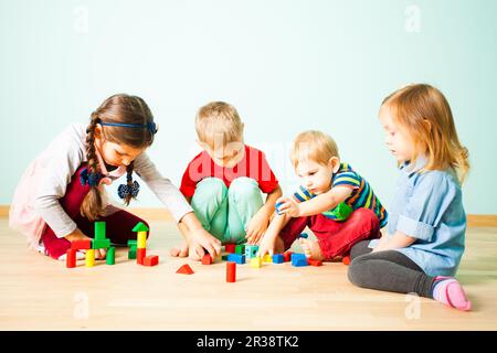 Kids playing with wooden blocks at kindergarten Stock Photo