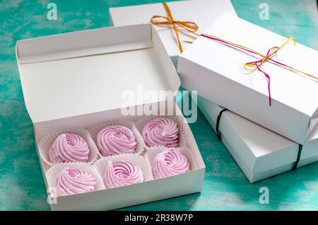 Pink zefir in a gift box on a blue surface Stock Photo
