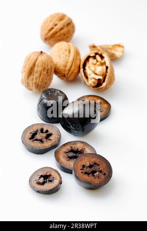 Walnuts, fresh and pickled, against a white surface Stock Photo