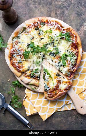 A three cheese pizza with rocket Stock Photo