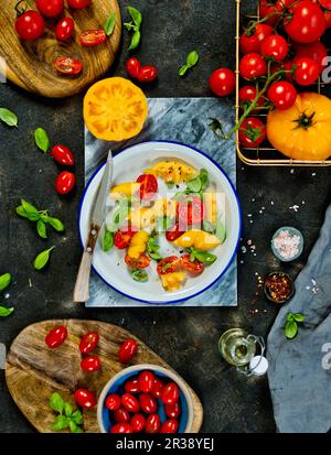 A salad of yellow and red tomatoes with basil Stock Photo