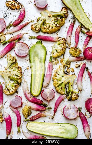 Roasted vegetables on a baking tray (seen from above) Stock Photo