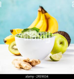 Ingredients for healthy Green smoothie on the table against the blue wall Stock Photo