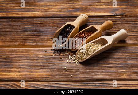 White, red and black quinoa seeds in the scoops Stock Photo