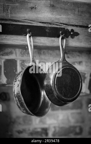 Antique pans hanging on a wooden beam Stock Photo