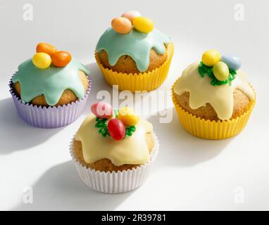 Colourful Easter muffins with icing and sugar eggs Stock Photo