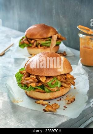 Two pulled chicken burgers on parchment paper Stock Photo