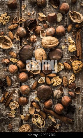 Various nuts, cinnamon sticks and star anise on a wooden surface Stock Photo