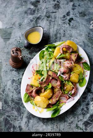 Potato salad with baby spinach and steak stripes Stock Photo