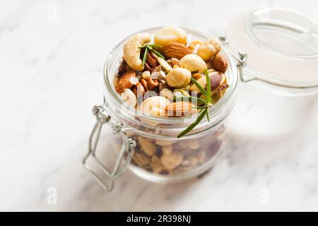 Mix of different types of nuts with salt and rosemary Stock Photo