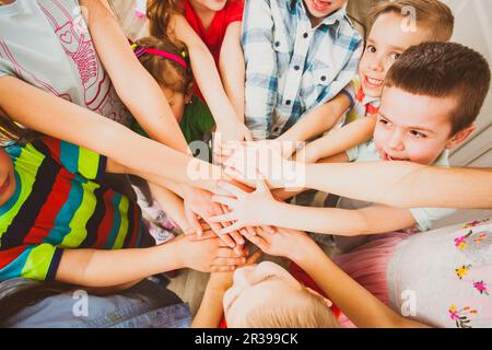 Little children putting their hands together outdoors. Unity, team work, friendship concept Stock Photo